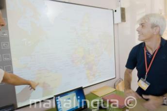 An engleză language profesor look at a whiteboard