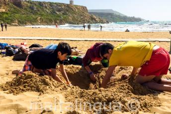 Group leader and kids digging a hole la plajă