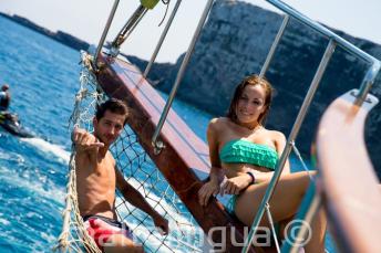 2 studenți lounging on the deck of a boat at Comino in Malta.