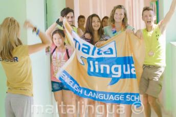 A group of studenți waving a flag in our vară campus