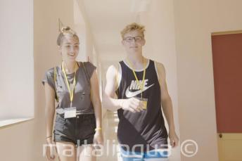 A teenage boy and girl walking through the language școală