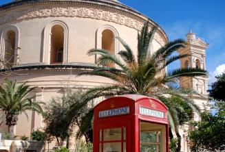 O cutie telefonică roșie în fața Mosta Rotunda