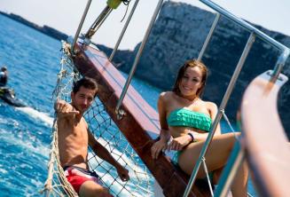 2 studenți lounging on the deck of a boat at Comino in Malta.