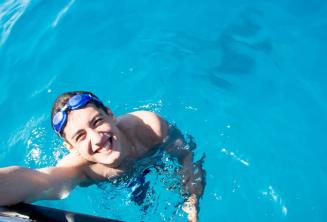 Un student înot lângă barcă la Comino.