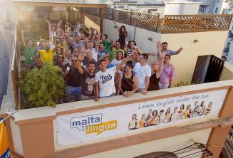 engleză language studenți waving on the școală's terasă de pe acoperiș terasă